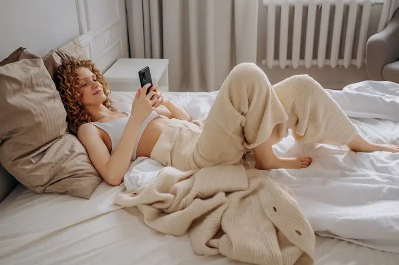 Femme couchée sur son lit avec des draps propres