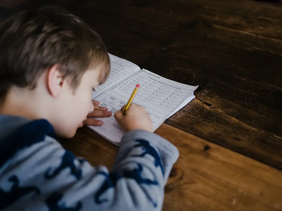 enfant faisant un exercice scolaire sur un bureau