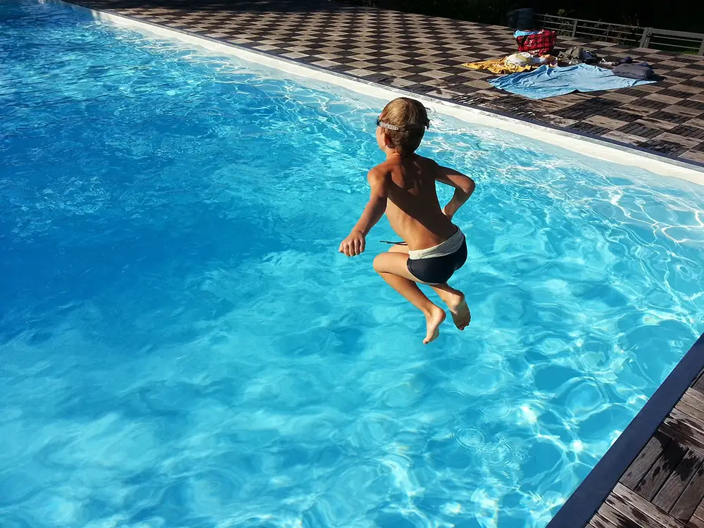 enfant sautant dans la piscine