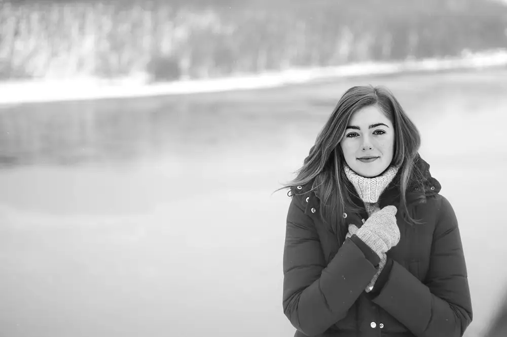 Jeune femme en extérieur en hiver avec un manteau et un foulard