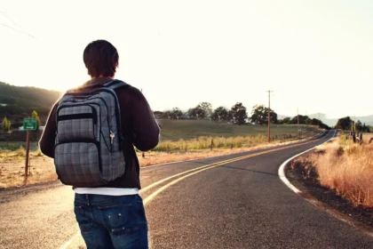 voyageur marchant au bord de la route avec un sac a dos