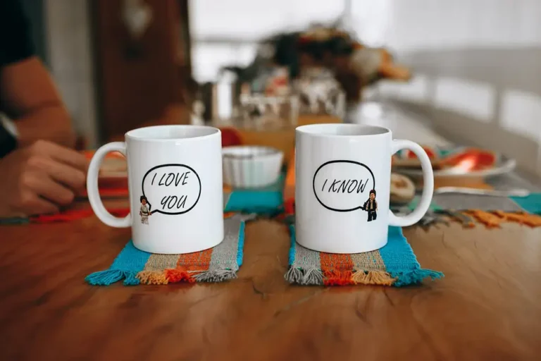 2 tasses sur une table, 2 objets personnalisés, l'un affichant I Love You, l'autre I Know.