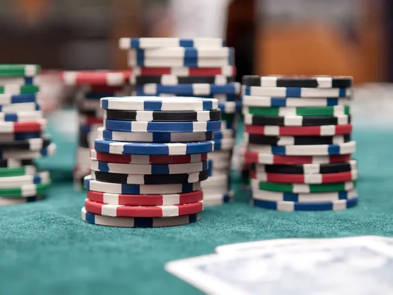 Jetons de casino en ligne colorés Lucky8 posés et empilés sur une table.