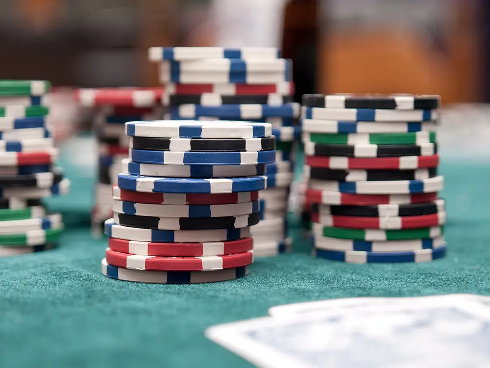 Jetons de casino en ligne colorés Lucky8 posés et empilés sur une table.