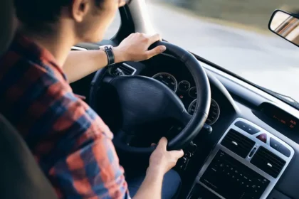 Jeune homme conduisant une voiture après avoir passé son permis de conduire et bénéficié du financement CPF