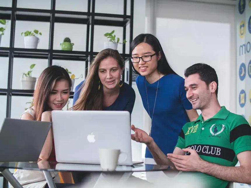 manager utilisant ses soft skills avec son équipe devant un ordinateur portable