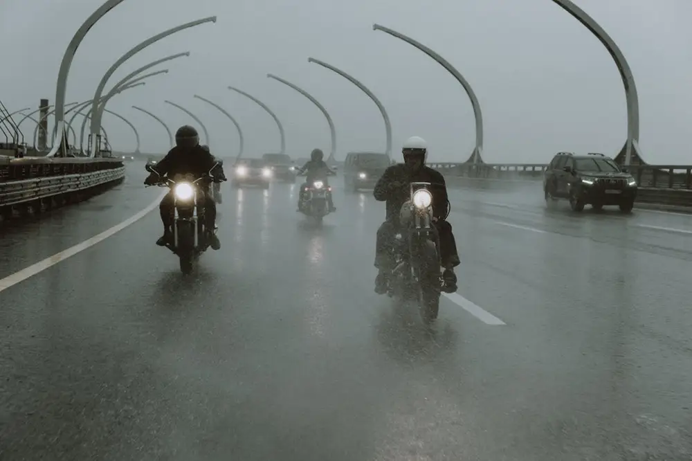 3 motos sur une autoroute avec phares allumés par une pluie battante