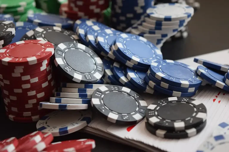 Jetons de casinos en ligne de différentes couleurs noirs, rouges, bleus, blancs