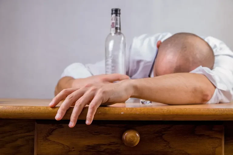 guérir dépendance à l'alcool - Homme endormi avec une bouteille d'alcool dans la main