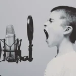 préserver son audition : enfant qui crie dans un microphone