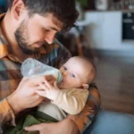 papa qui donne le biberon à son enfant