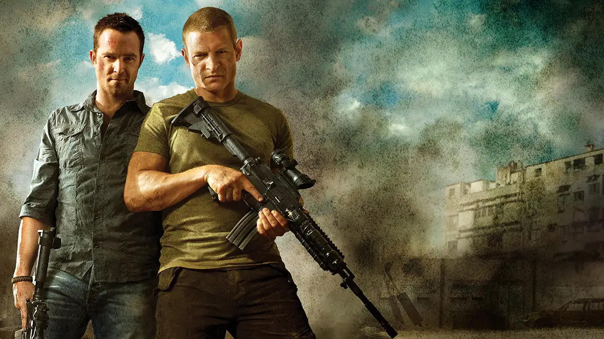 Affiche promotionnelle de la série d'action Strike Back, avec les deux acteurs principaux tenant des fusils de guerre, et en arrière plan de la fumée résiduelle d'explosions