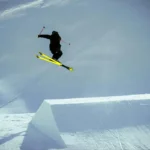 Jo Milan Italie 2026 skieur acrobatique en plein saut depuis un tremplin