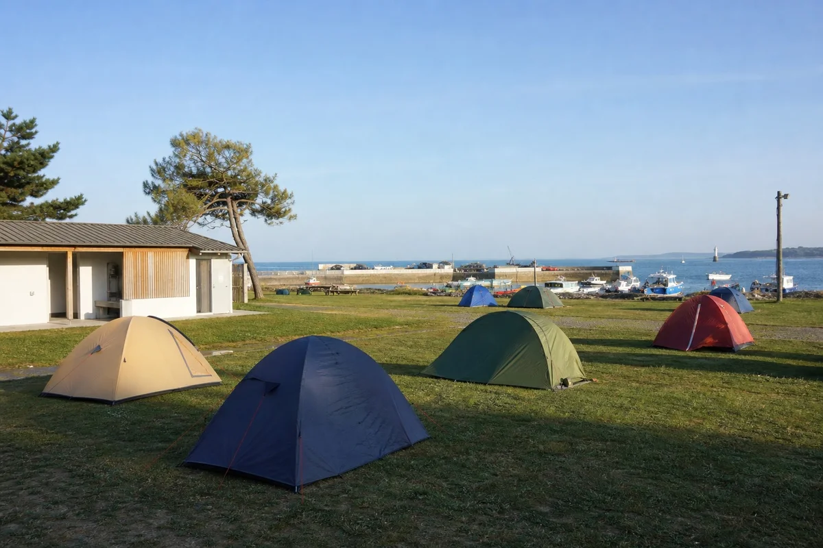 Camping municipal bord de mer Bretagne famille Tentes plantées dans un camping municipal breton face au port, vue sur la mer