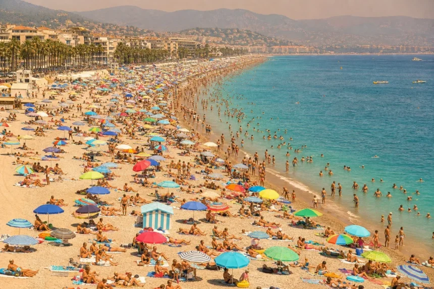 Plage méditerranéenne bondée sous forte chaleur estivale en France