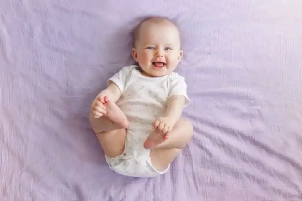 bébé souriant couché , image d'illustration pour l'article sur les masseurs d'allaitement