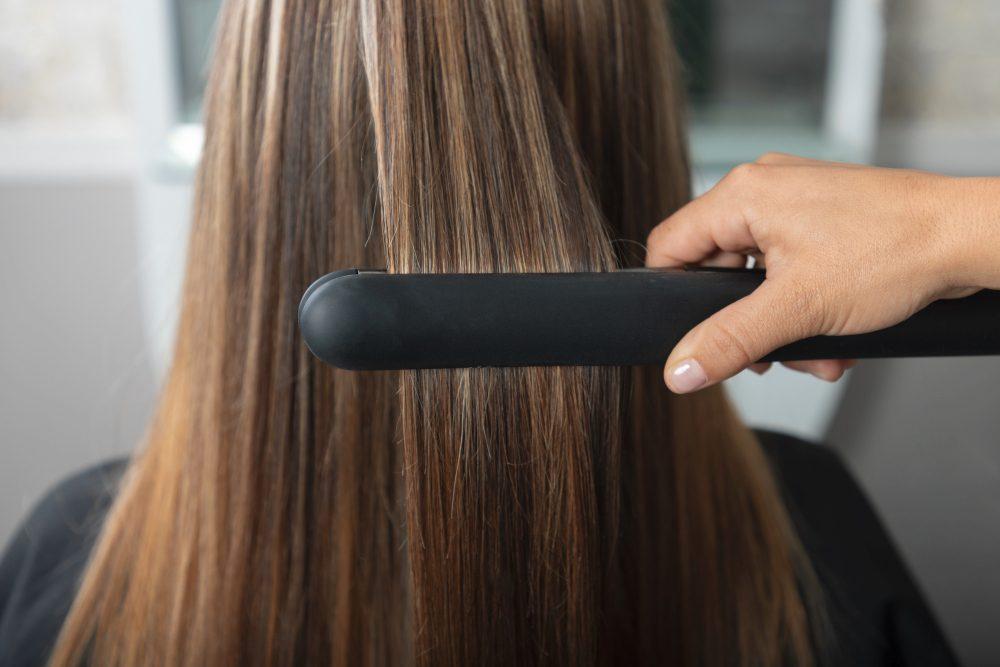 Femme se faisant lisser les cheveux dans un salon de coiffure